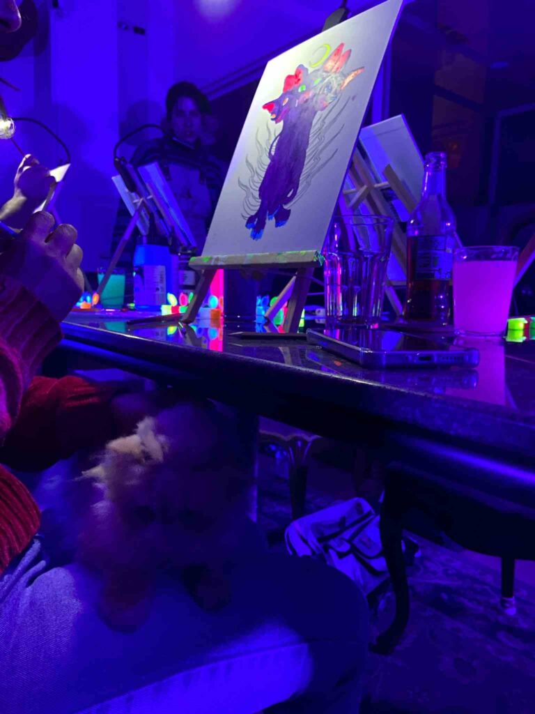 Grupo pintando con pintura neón junto a gatos abandonados