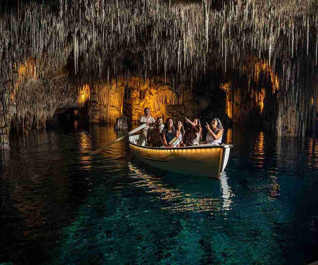 Grupo disfrutando de un paseo en barco iluminado por las cuevas del drach