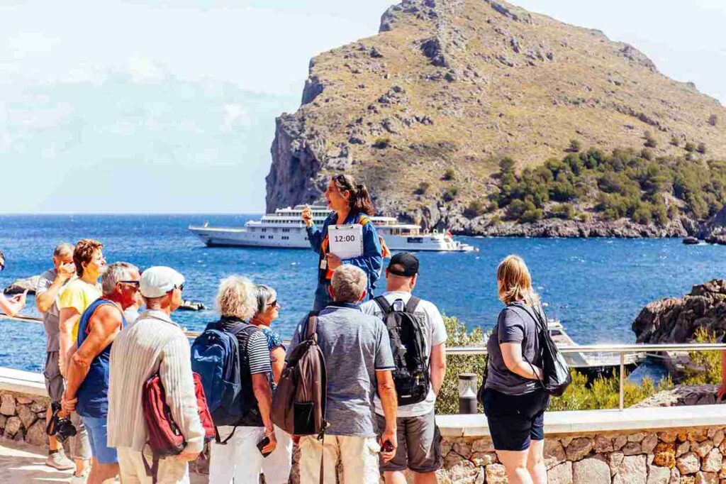 Turistas escuchando a su guía antes de subir al barco en su excursión por Mallorca