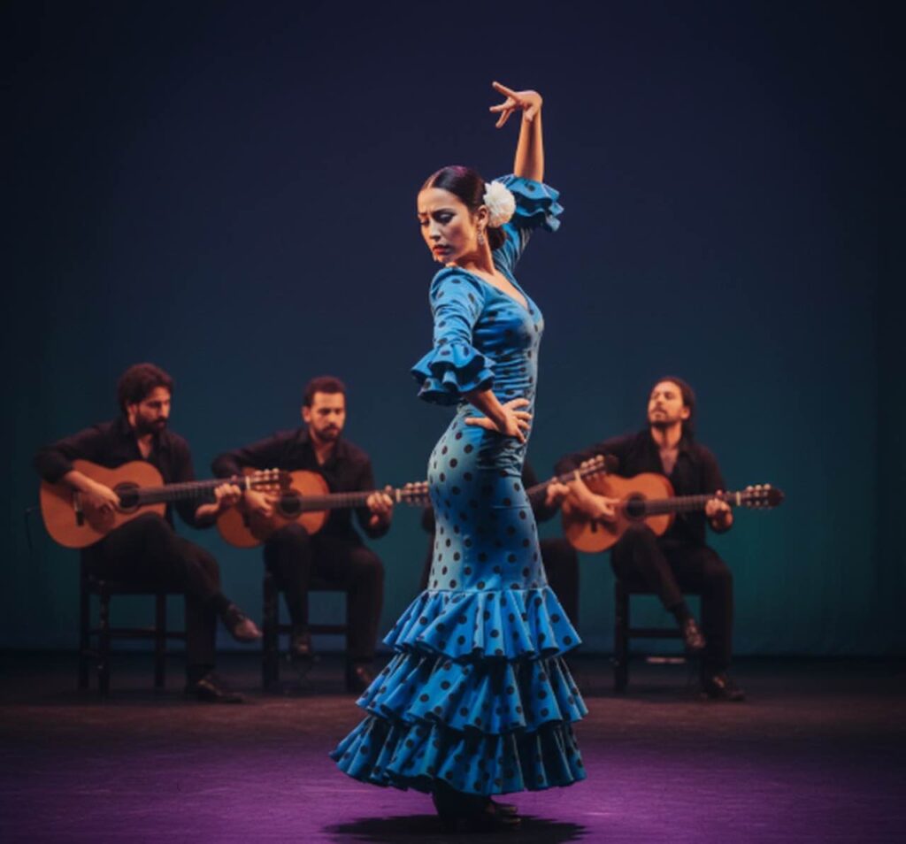 Bailaora con traje azul en tablao flamenco con guitarra española