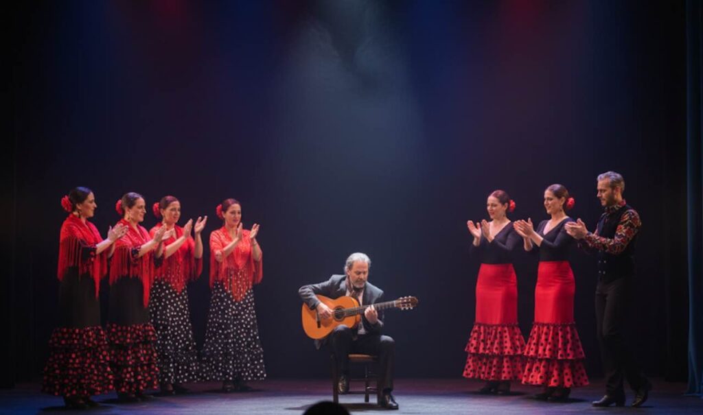 Guitarrista flamenco rodeado de bailaoras en Sevilla