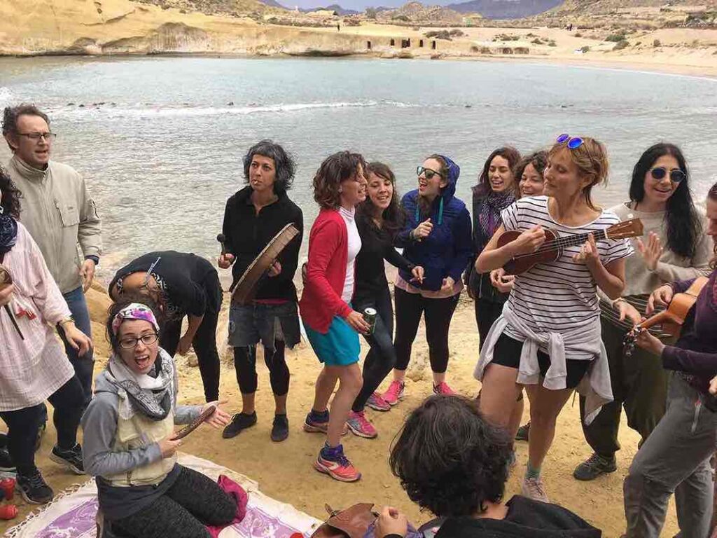Gente bailando al ritmo de guitarras cerca de un lago en un retiro
