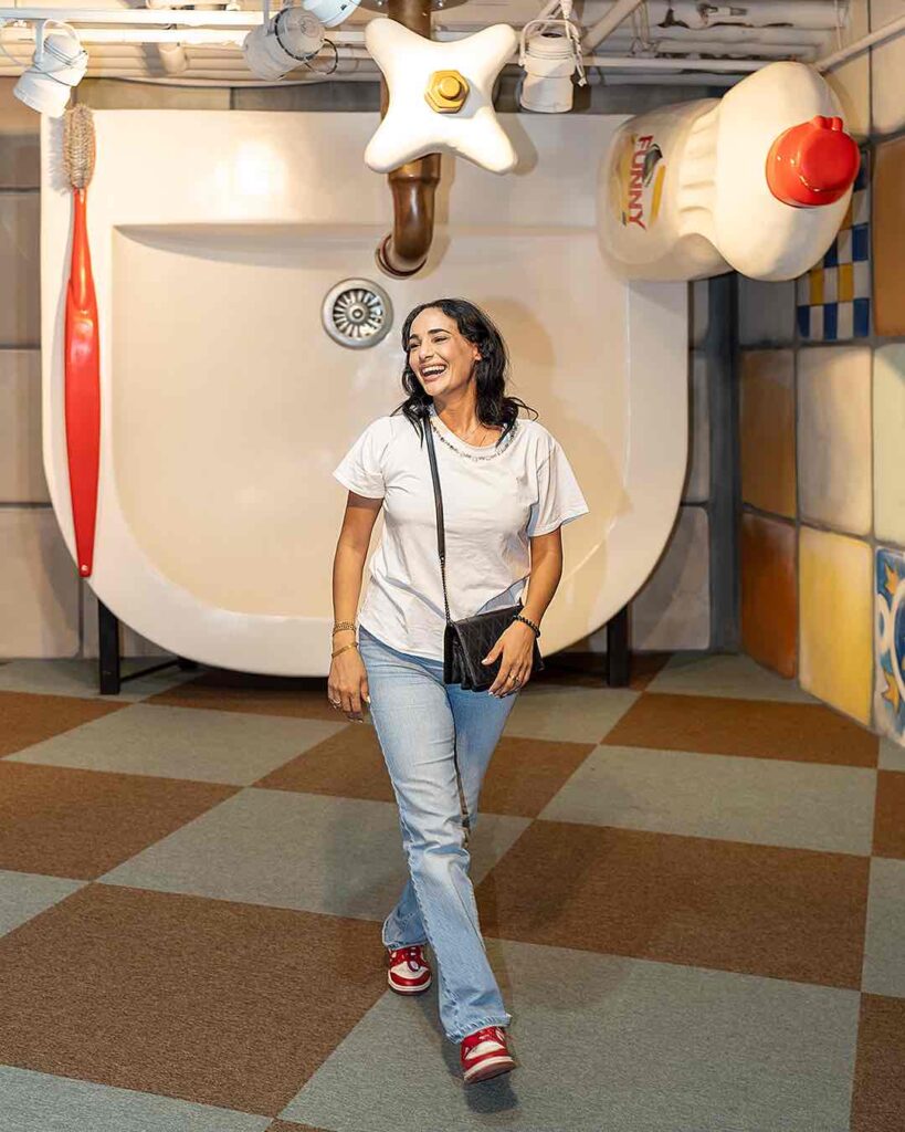 Foto divertida de una chica en un baño gigante en el museo Big Fun