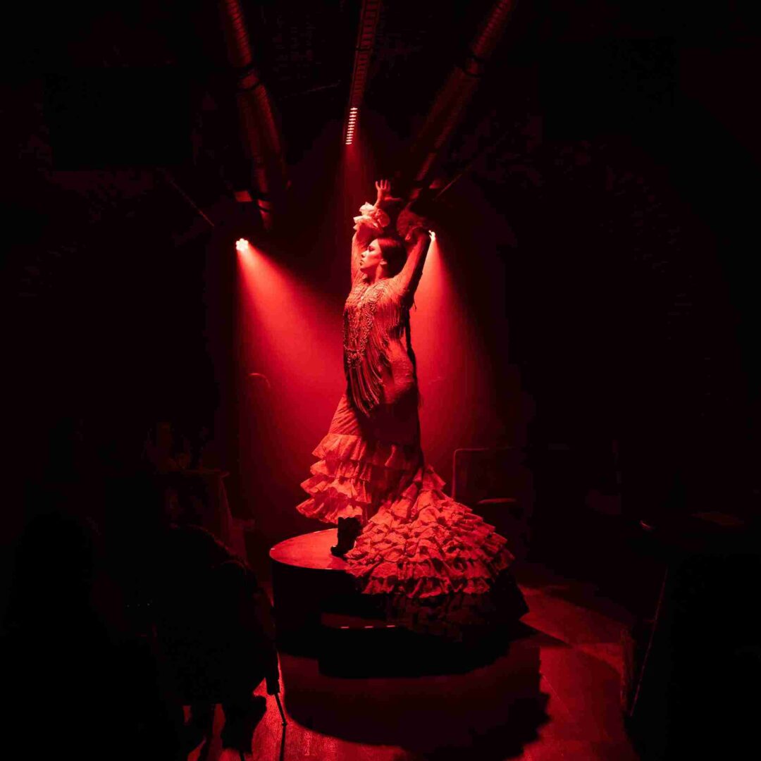 Bailaora flamenca con vestido rojo subida al tablao