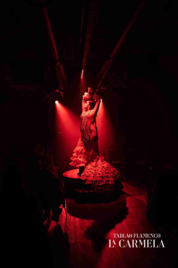 Bailaora flamenca con vestido rojo subida al tablao