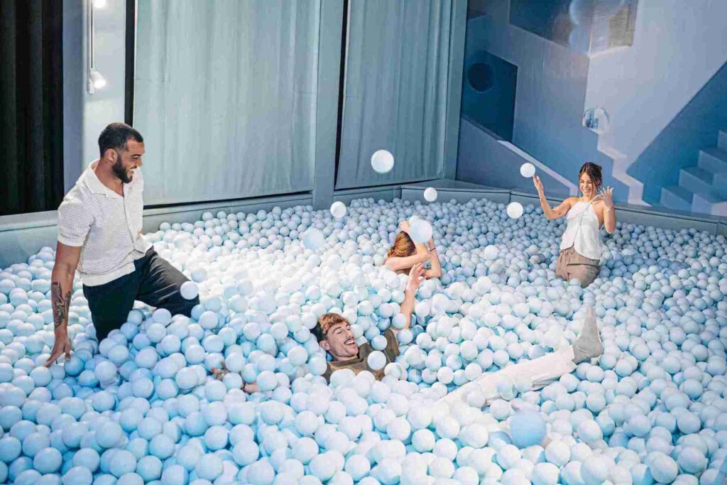 Chicos disfrutando de la piscina de bolas azules para adultos de IKONO