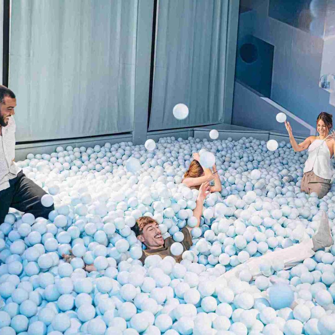 Chicos disfrutando de la piscina de bolas azules para adultos de IKONO